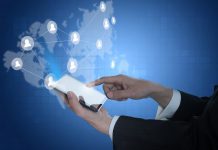 Bahrain, Japan MoU digital services - GCC Business News Finger touching mobile screen with world map in the background, showing global connectivity, digital services